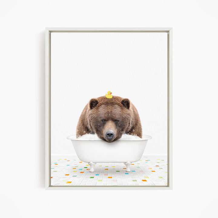 A brown bear is sitting in a white bathtub, with a yellow rubber duck perched on its head.