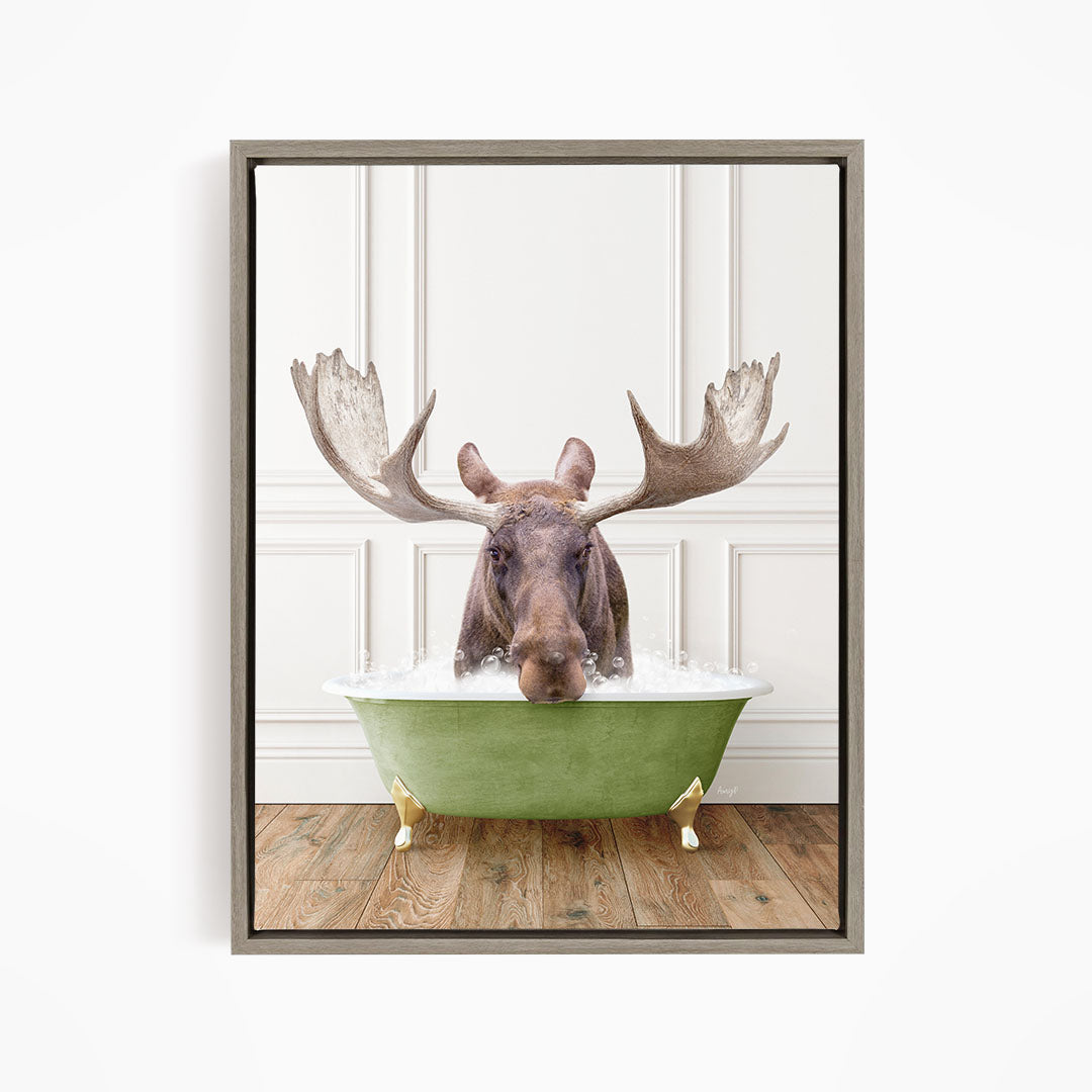 A moose with large antlers is sitting in a green bathtub filled with water, creating a whimsical and humorous scene.