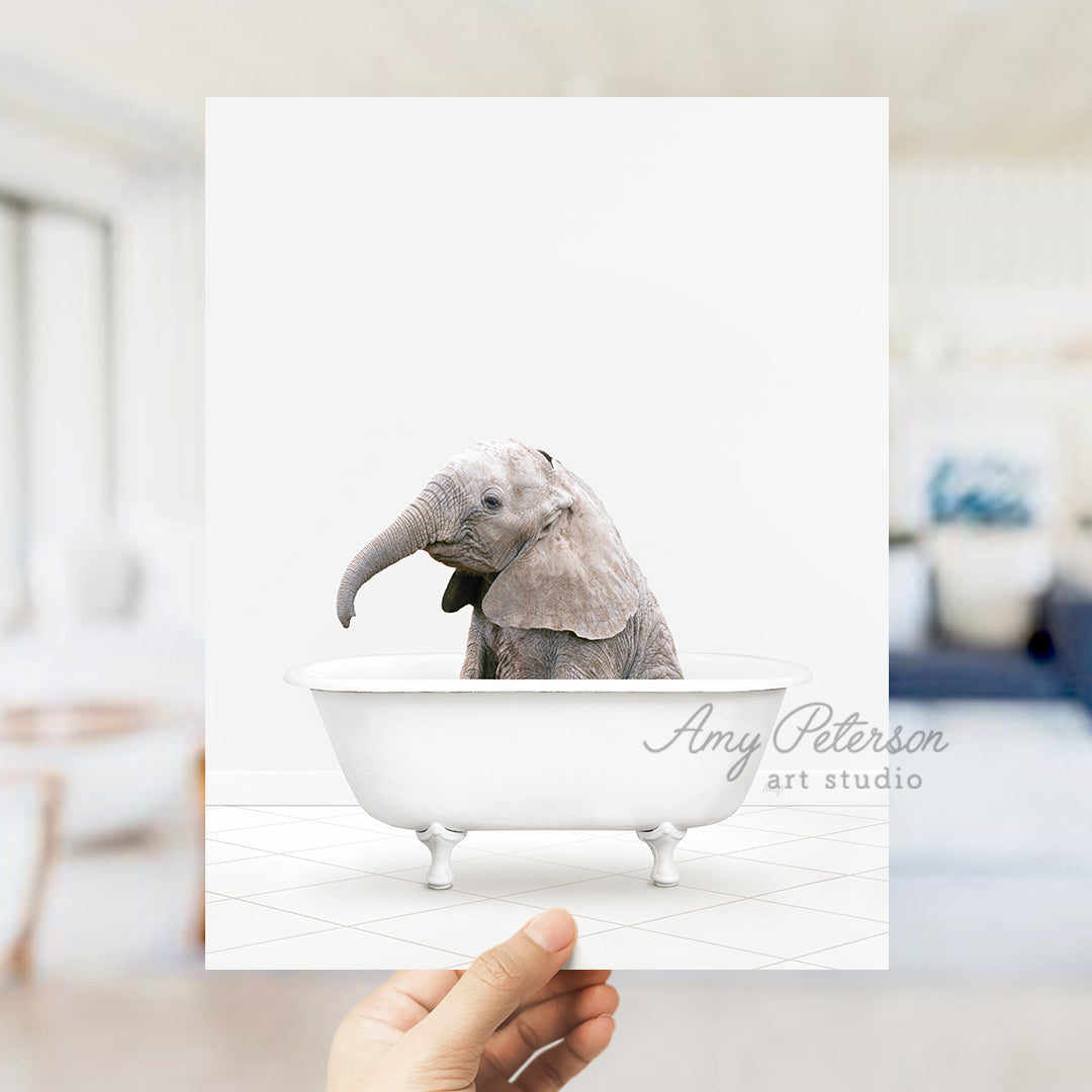 a person holding up a card with an elephant in a bathtub