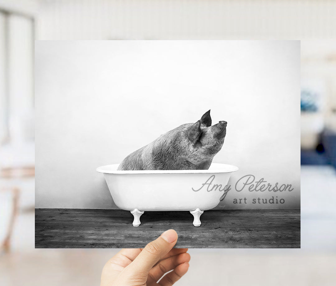 a hand holding up a black and white photo of a dog in a bathtub