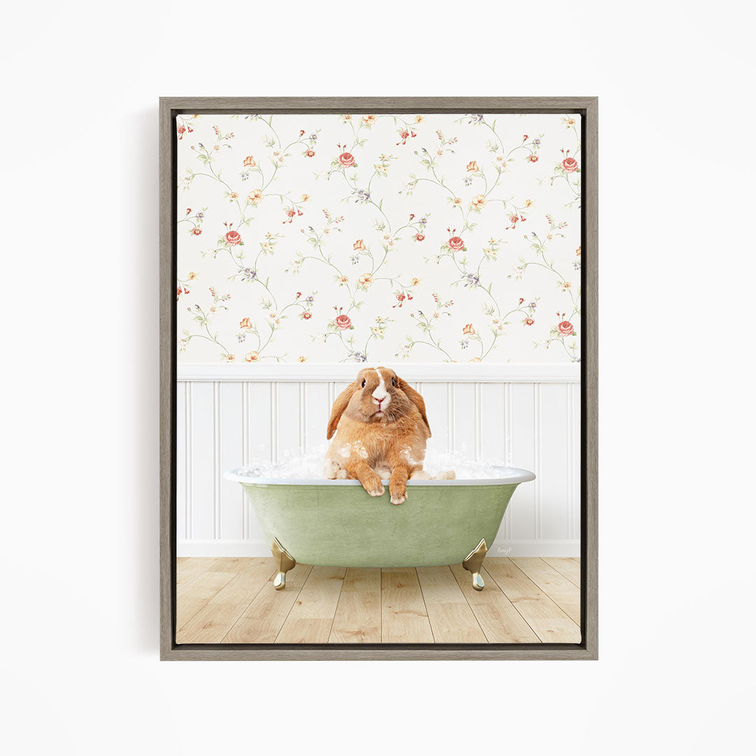 A brown rabbit sitting in a green bathtub filled with water, with a floral wallpaper in the background.