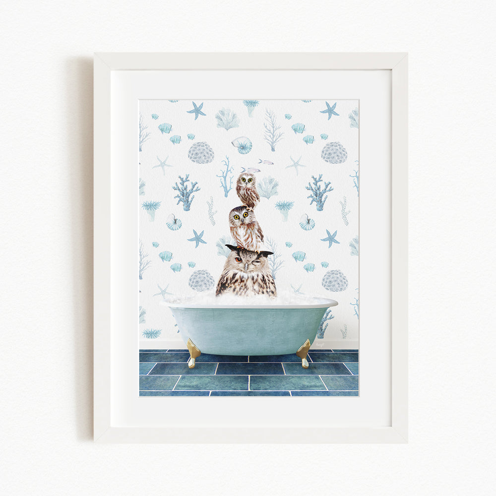 A framed print depicting an owl perched on the edge of a bathtub filled with water, surrounded by a blue and white ocean-themed wallpaper.