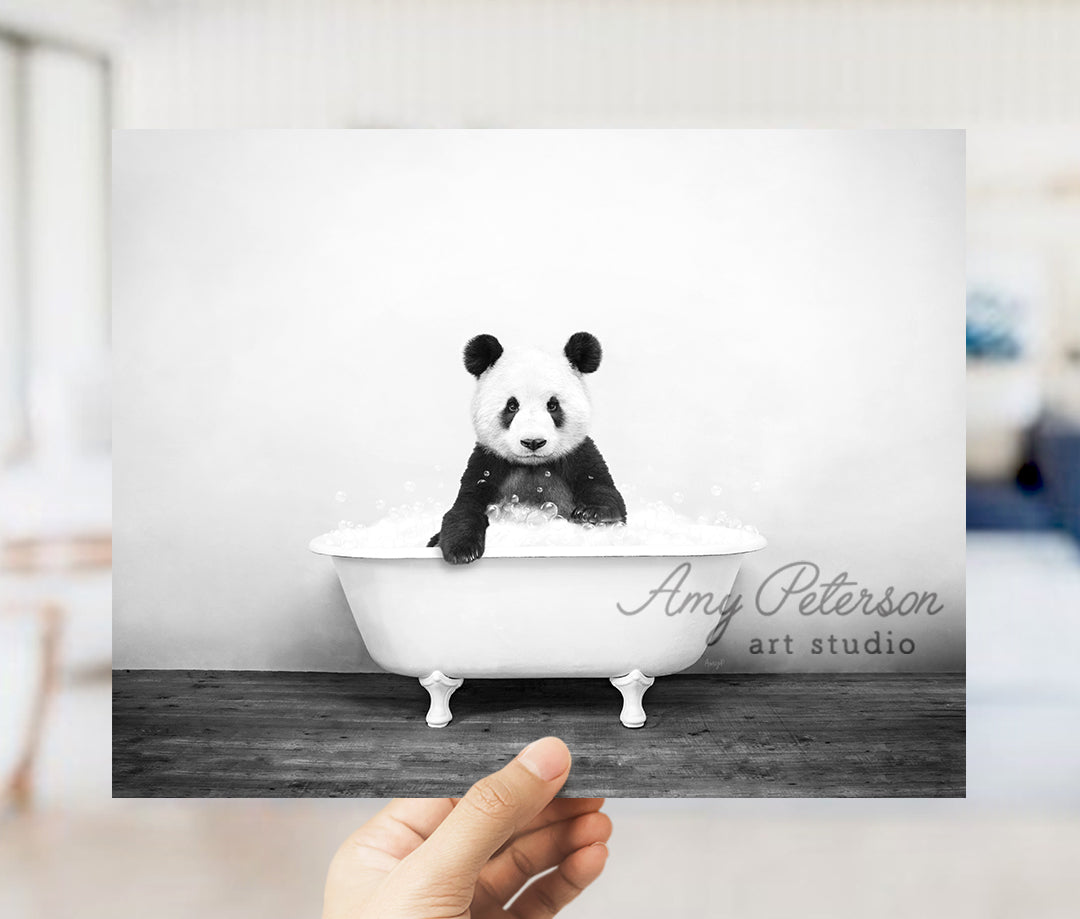 a person holding up a black and white photo of a panda in a bathtub