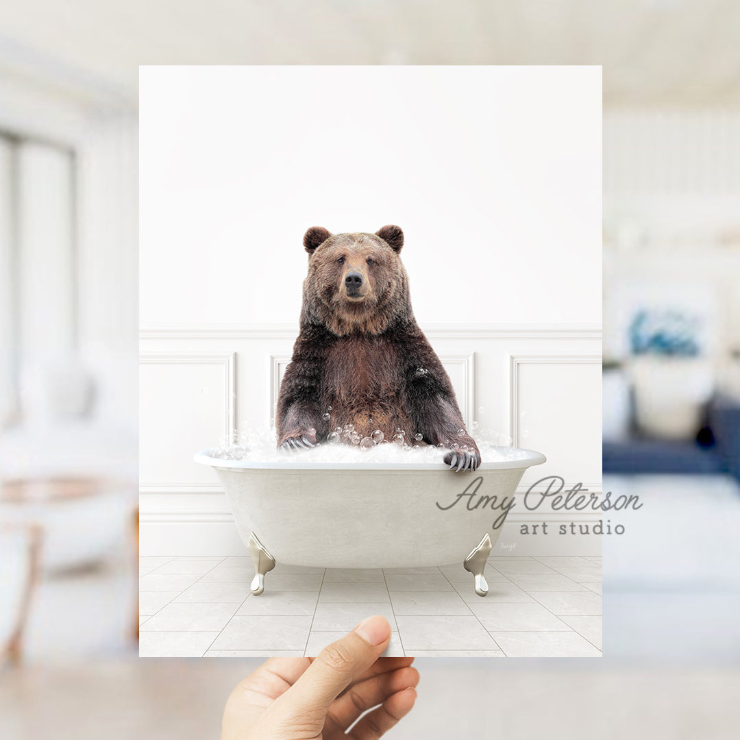 a person holding up a polaroid picture of a bear in a bathtub