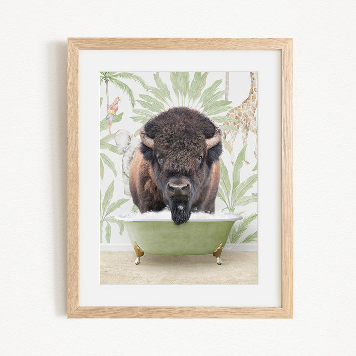 A framed image depicting a bison with a giraffe in the background, both in a green bathtub.