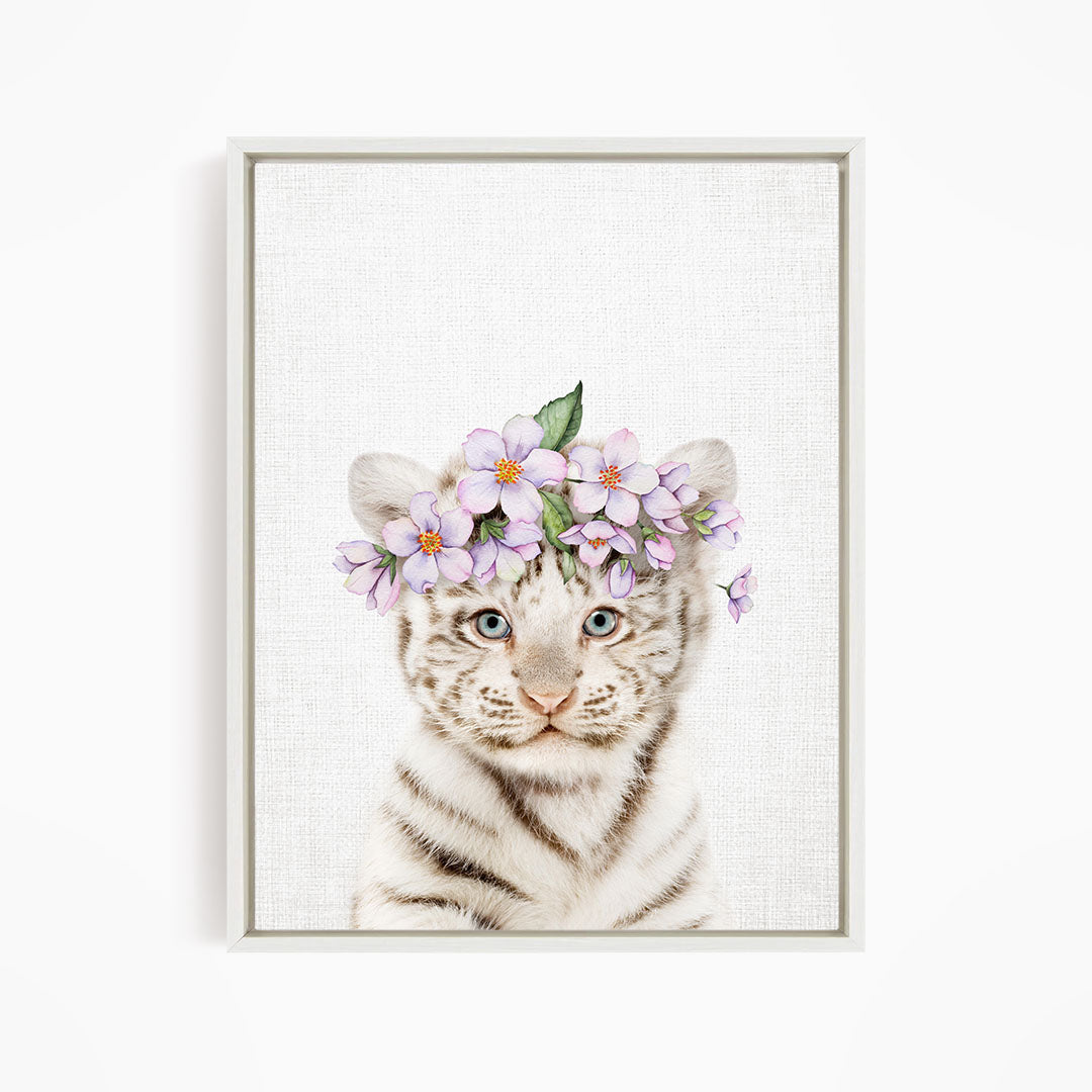 A young tiger cub wearing a floral headpiece with purple flowers.