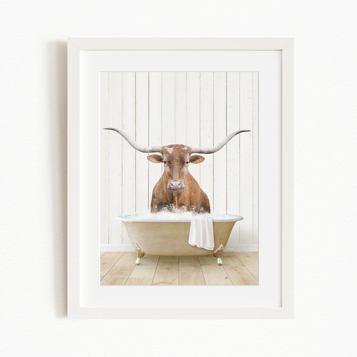 A brown cow with large horns is sitting in a white bathtub filled with water, creating a whimsical and humorous scene.