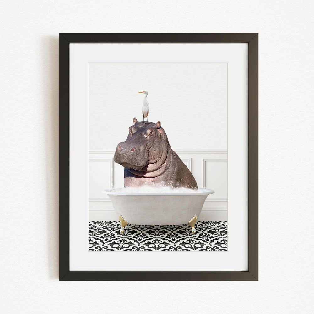 A framed image depicting a large hippopotamus sitting in a bathtub, with a seagull perched on its head.