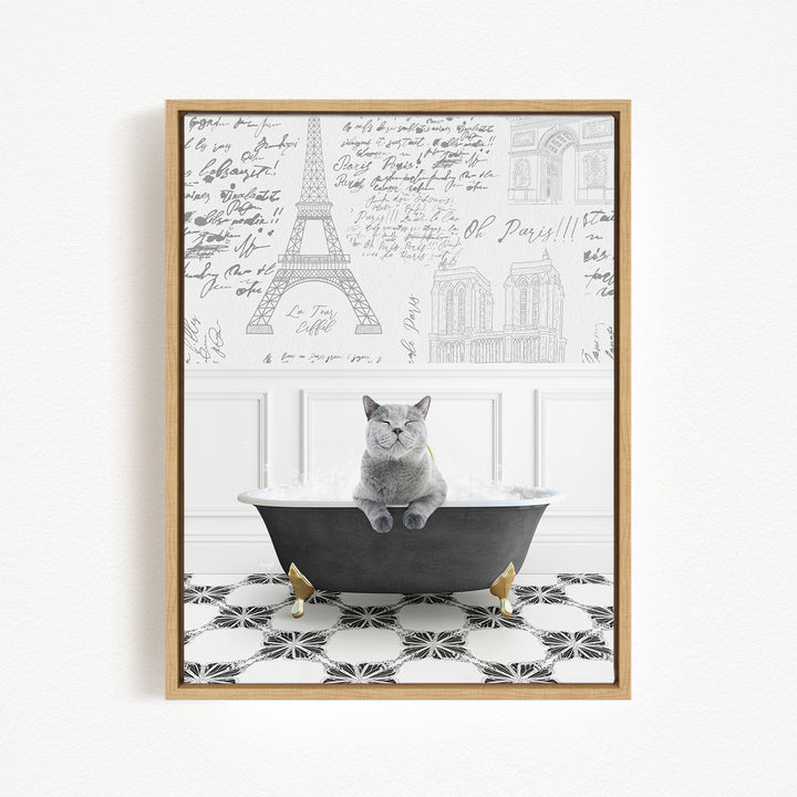 A gray cat sitting in a bathtub filled with bubbles, with the Eiffel Tower and other Parisian landmarks visible in the background.