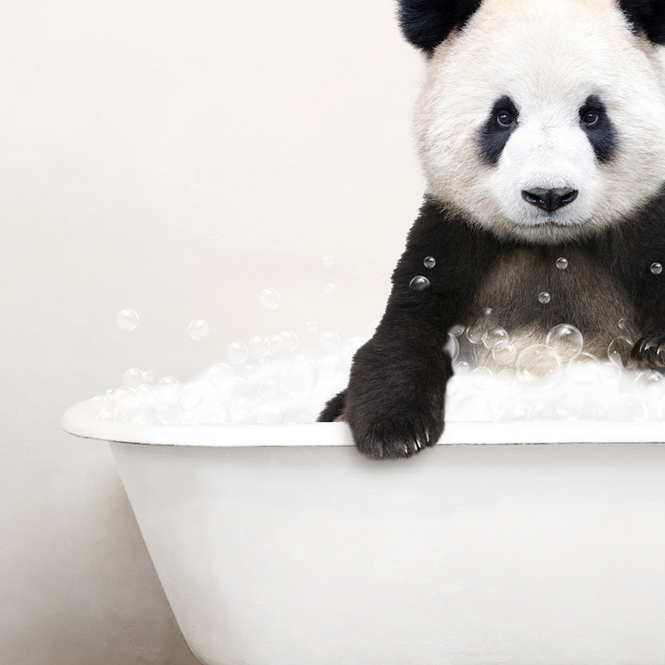 a panda bear sitting in a bathtub full of bubbles