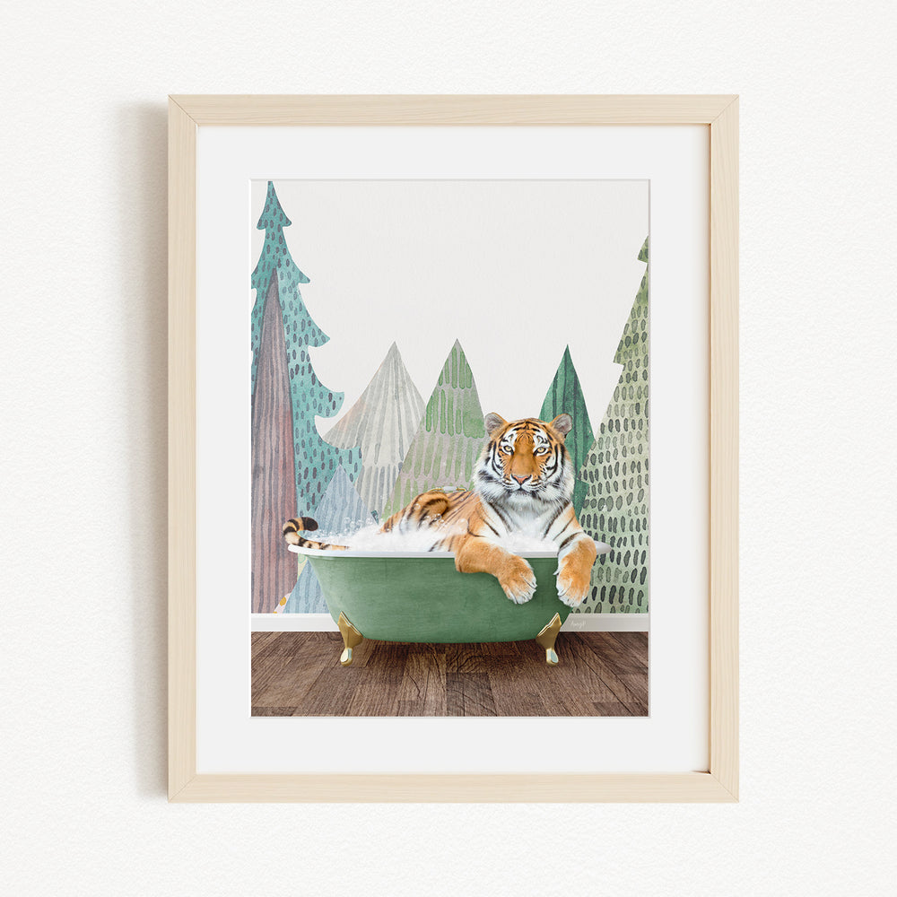 A tiger is sitting in a green bathtub, surrounded by trees and mountains in the background.