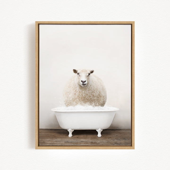 A fluffy white sheep sits in a white bathtub filled with bubbles, looking directly at the camera.