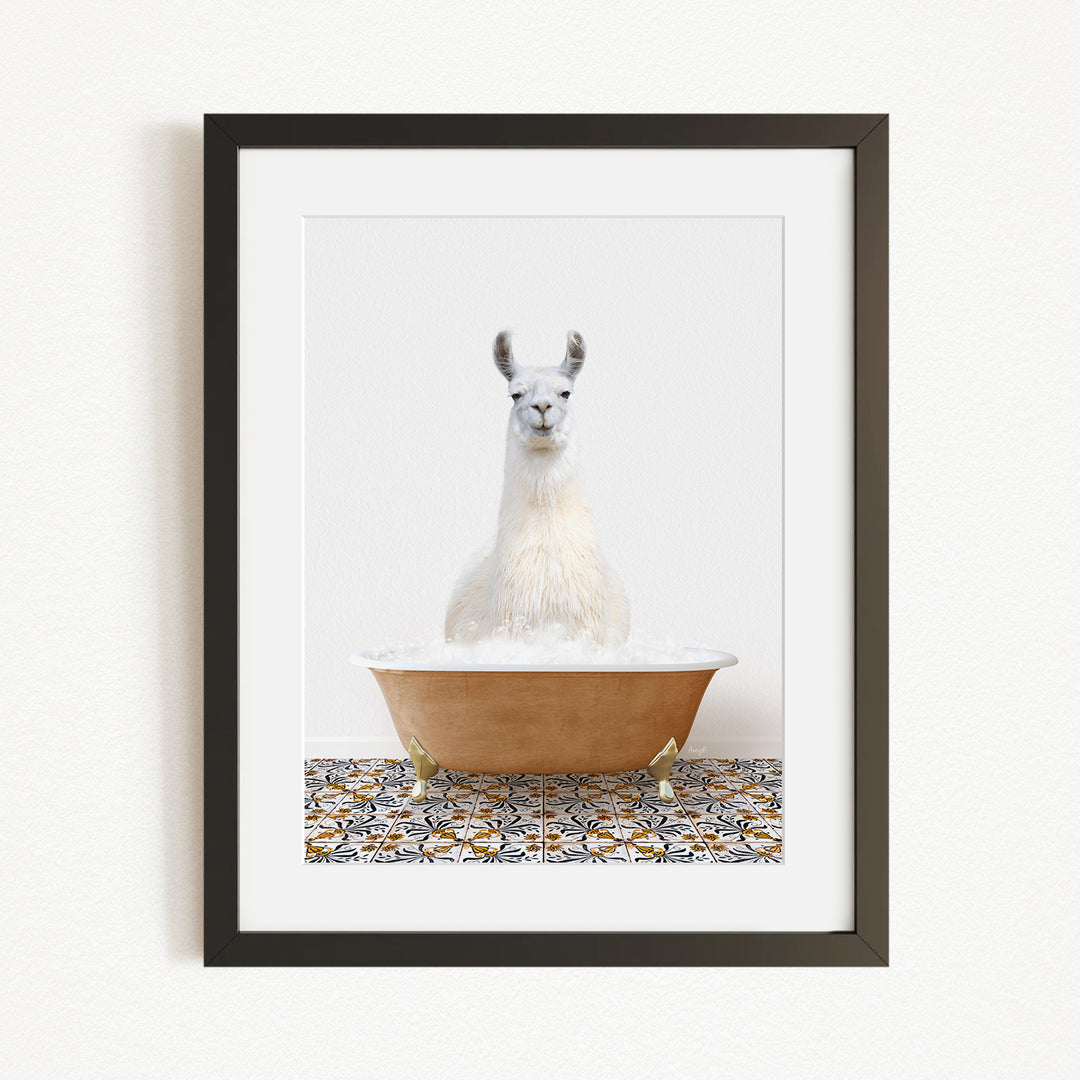 A white llama sitting in a bathtub filled with bubbles, with a patterned tile floor in the background.