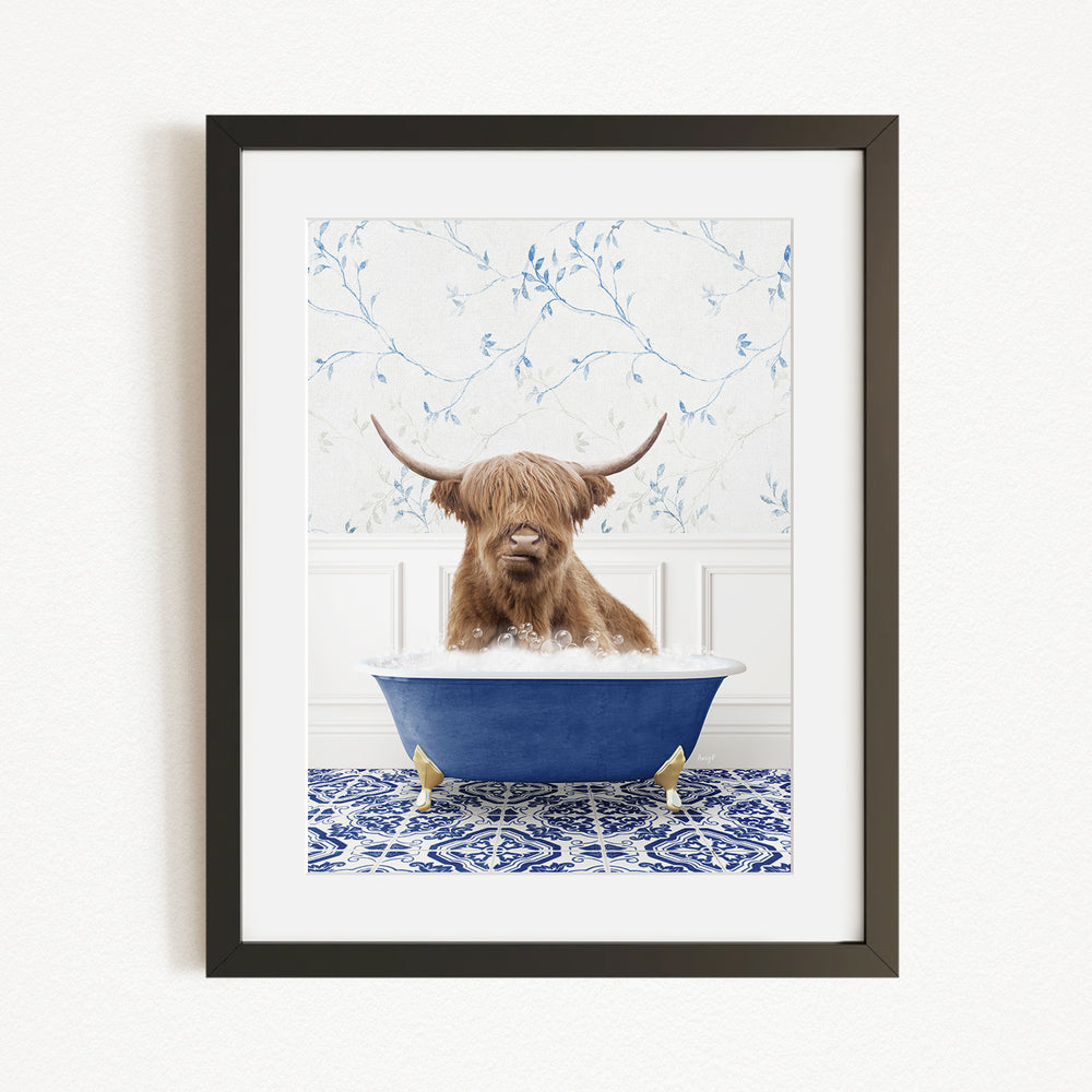 A brown cow with long horns is sitting in a blue bathtub, surrounded by a blue and white patterned rug and a white wall with blue floral wallpaper.