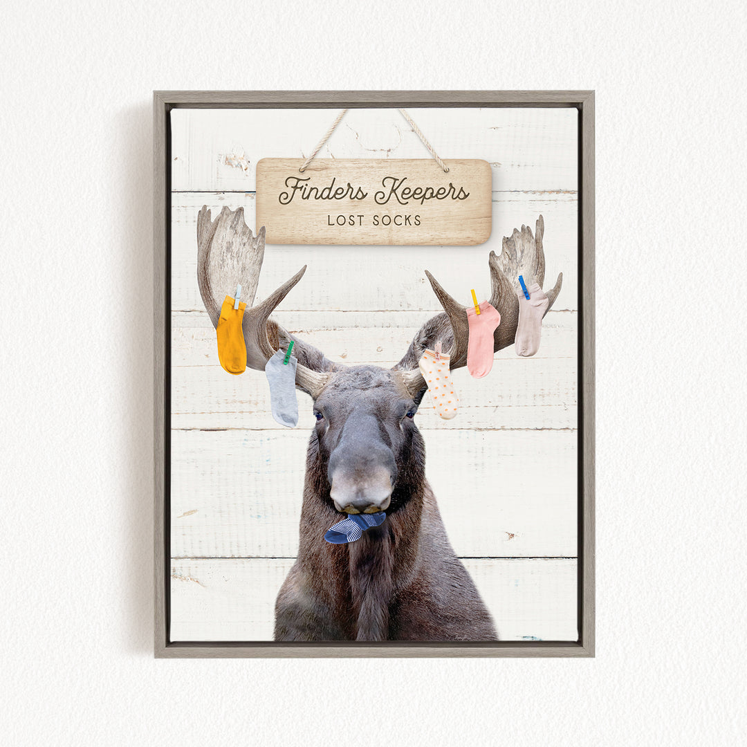 A framed image of a moose with a sign that says "Finders Keepers Lost Socks" hanging above it.