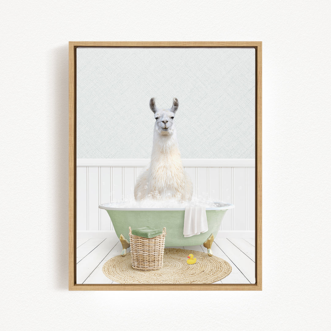 A white llama sitting in a green bathtub filled with bubbles, surrounded by a basket of bath toys and a yellow rubber duck.