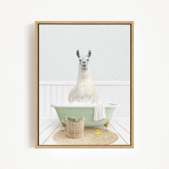 A white llama sitting in a green bathtub filled with bubbles, surrounded by a basket of bath toys and a yellow rubber duck.
