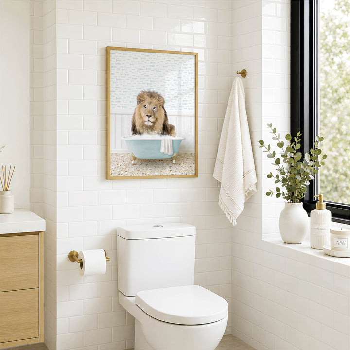 a bathroom with a white toilet, a framed picture of a lion in a bathtub, and a towel hanging on the wall.