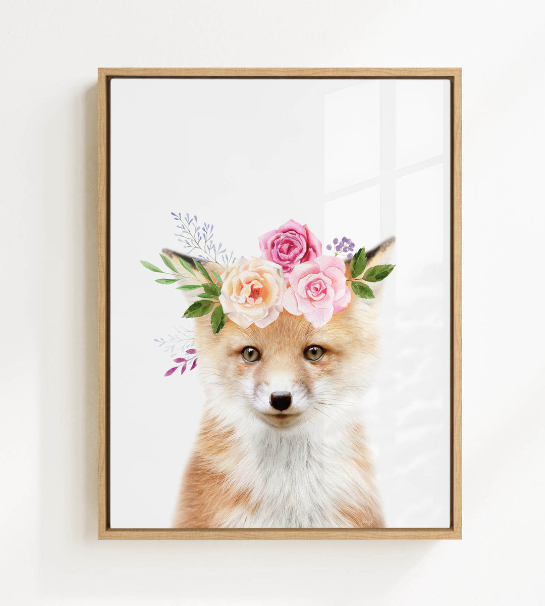 A framed print of a fox wearing a floral crown of pink and white roses and greenery.