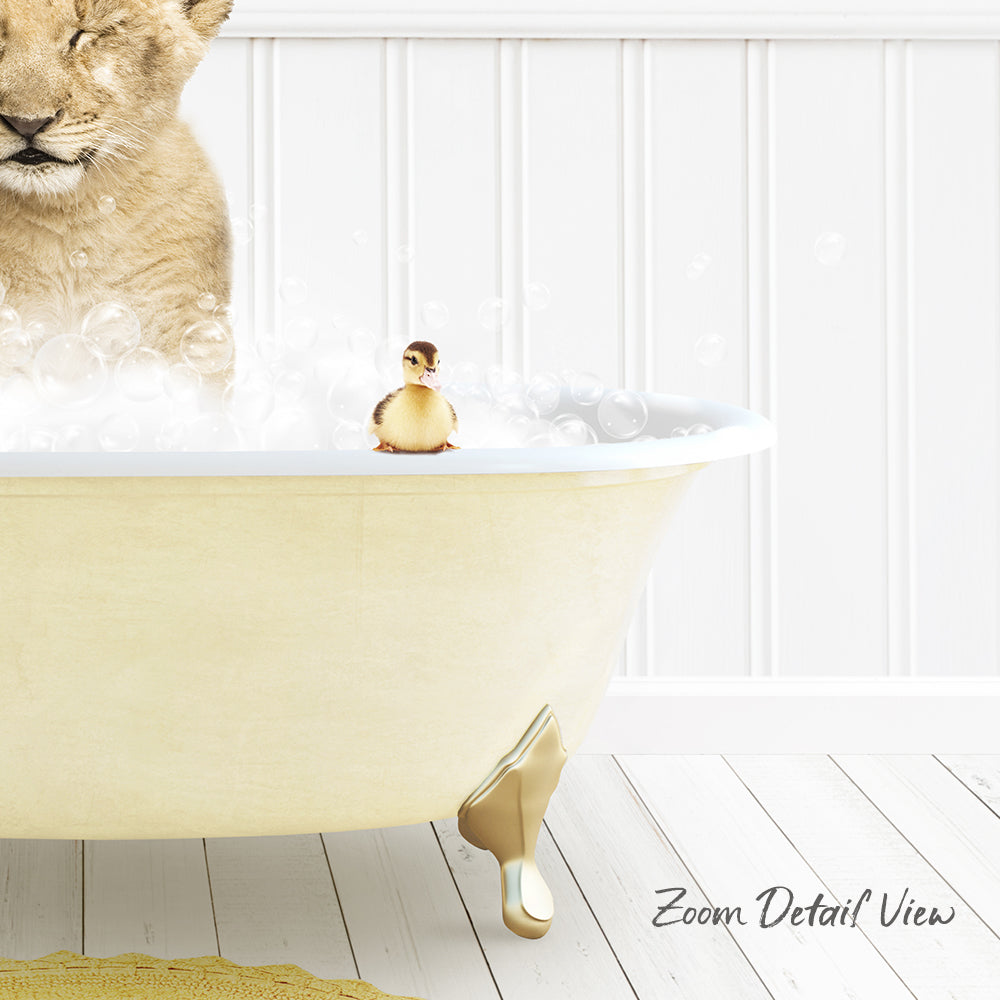 A lion cub is taking a bath in a white bathtub, with a small yellow duck sitting on the edge of the tub.