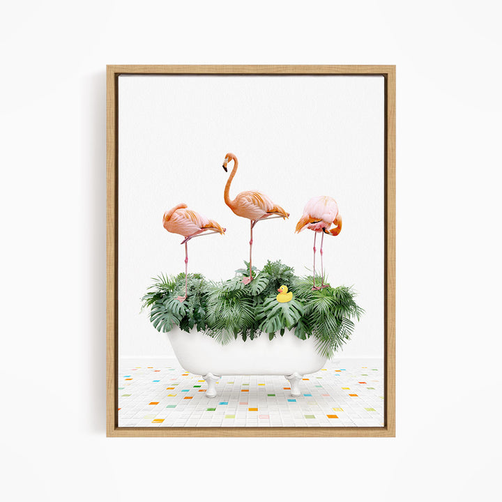 A framed image depicting three flamingos standing in a white bathtub filled with green plants and a yellow rubber duck.