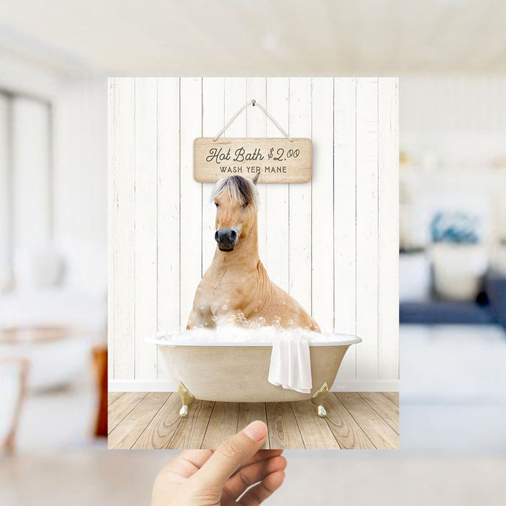 A hand holding a framed image of a horse sitting in a bathtub, with a sign above it that says "Hot Bath $2.00 WASH YE MANE".