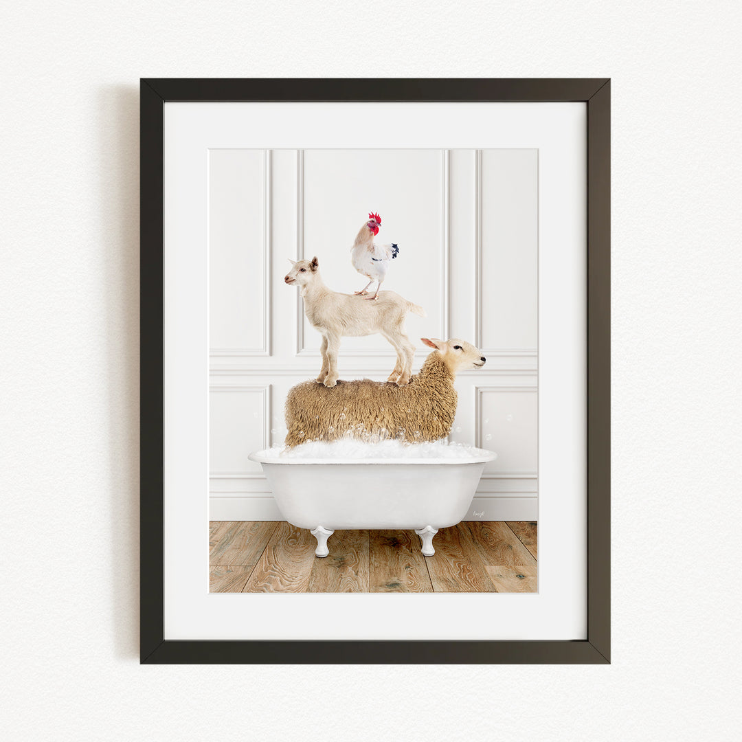 A framed image depicting a goat standing on a sheep's back while a rooster stands on top of a sheep in a bathtub.