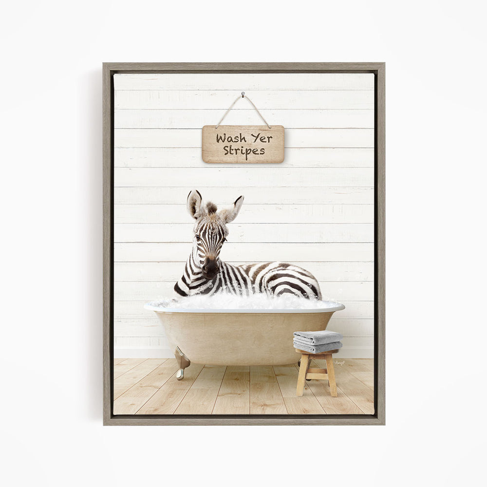 A zebra is sitting in a bathtub, with a sign above it that says "Wash Yer Stripes".