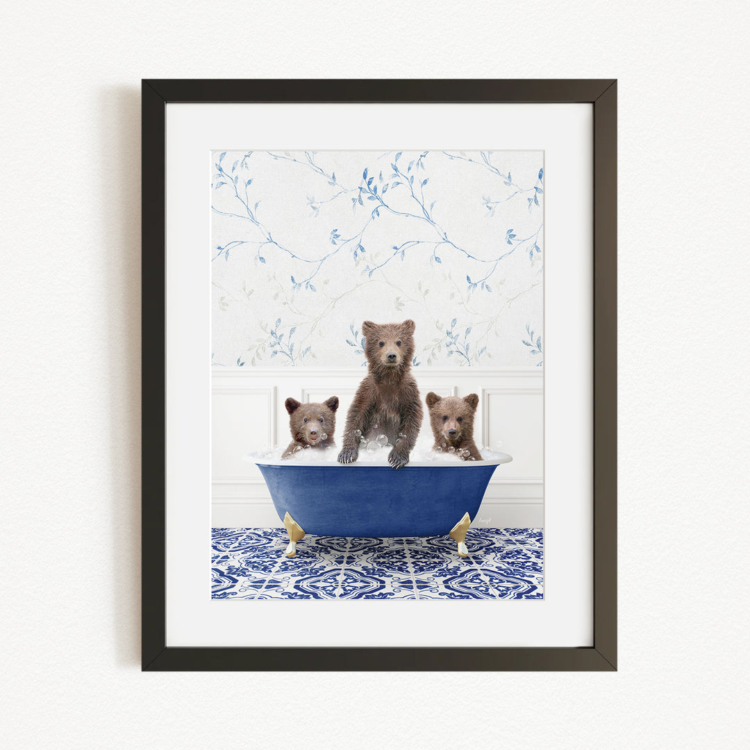 A framed image depicting three brown bears sitting in a blue bathtub, with a floral patterned wall behind them.