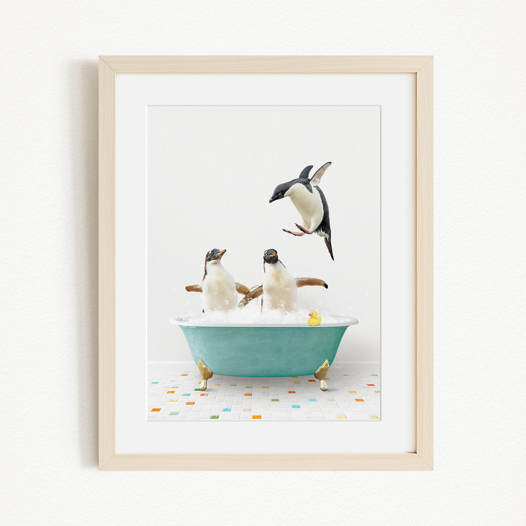 A framed image depicting two penguins sitting in a bathtub filled with bubbles, with one penguin standing on its hind legs and another penguin sitting on its belly.