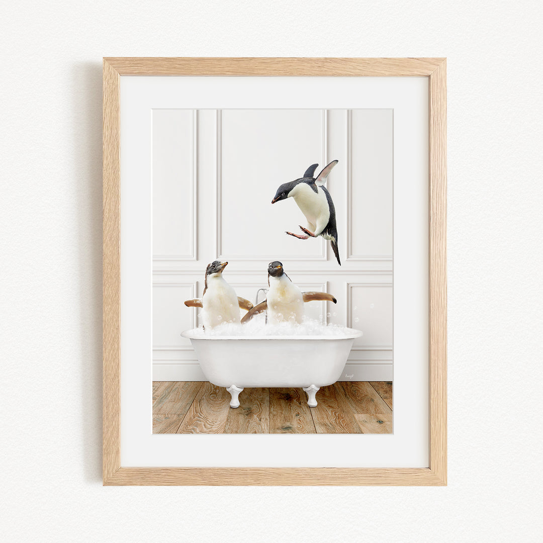 A framed image depicting two penguins sitting in a bathtub, with one penguin flying towards the other.
