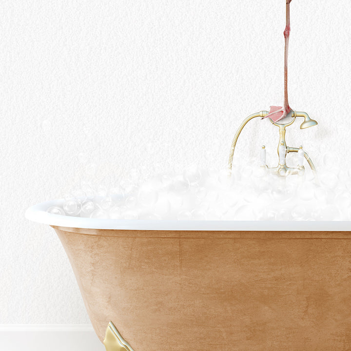 a bathtub filled with white foam and a pink flower