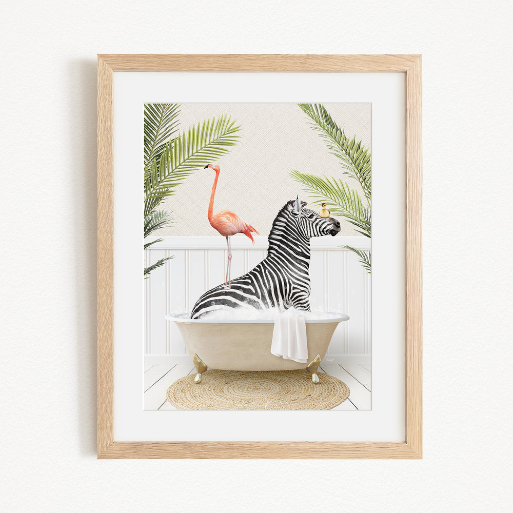 A framed image depicting a zebra sitting in a bathtub, with a pink flamingo standing on the edge of the tub.