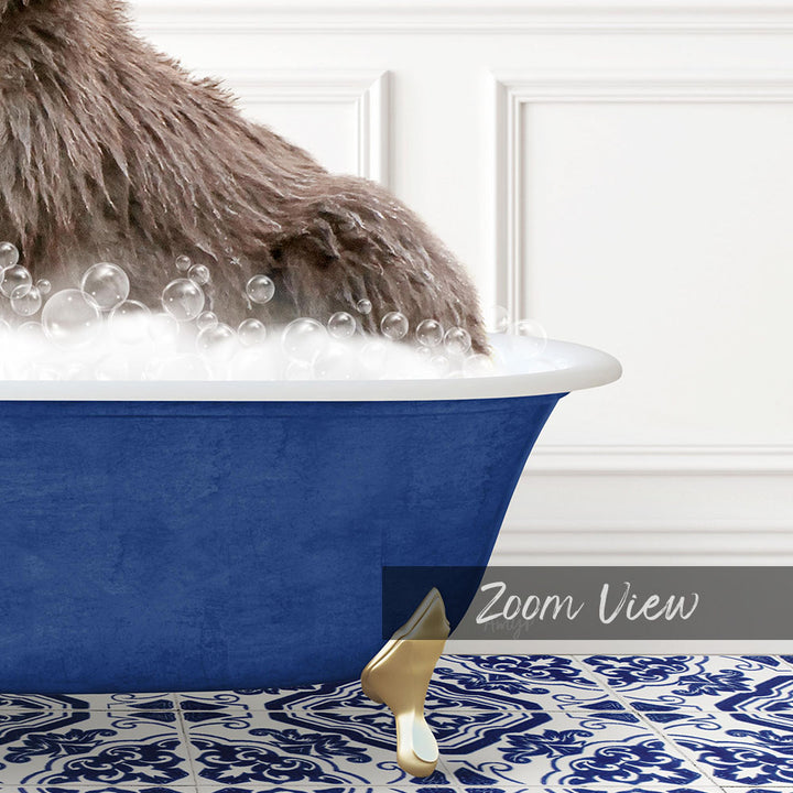 A fluffy brown dog is sitting in a blue bathtub filled with bubbles, with a gold claw-like object on the floor next to the tub.