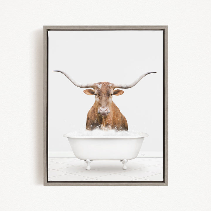 A brown cow with long horns is sitting in a white bathtub filled with water, creating a whimsical and humorous scene.
