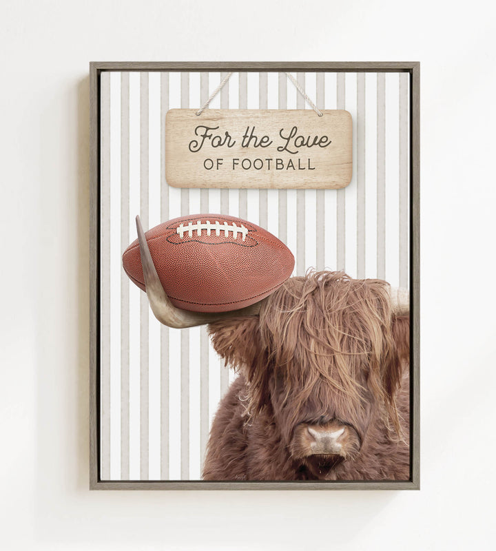 A framed image featuring a Highland cow with a football on its head, accompanied by a wooden sign that reads "For the Love of Football".
