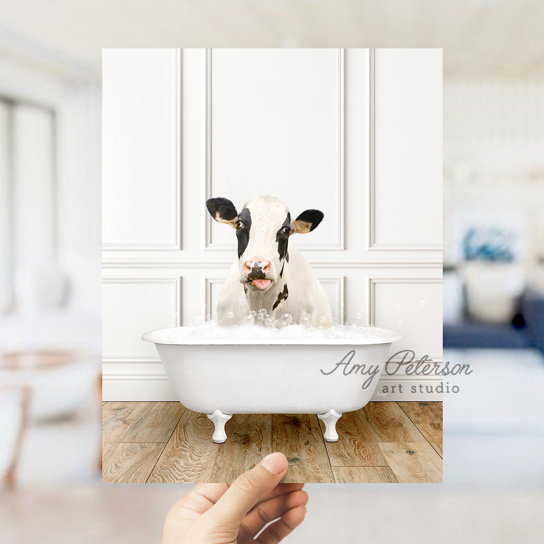 a person holding a photo of a cow in a bathtub