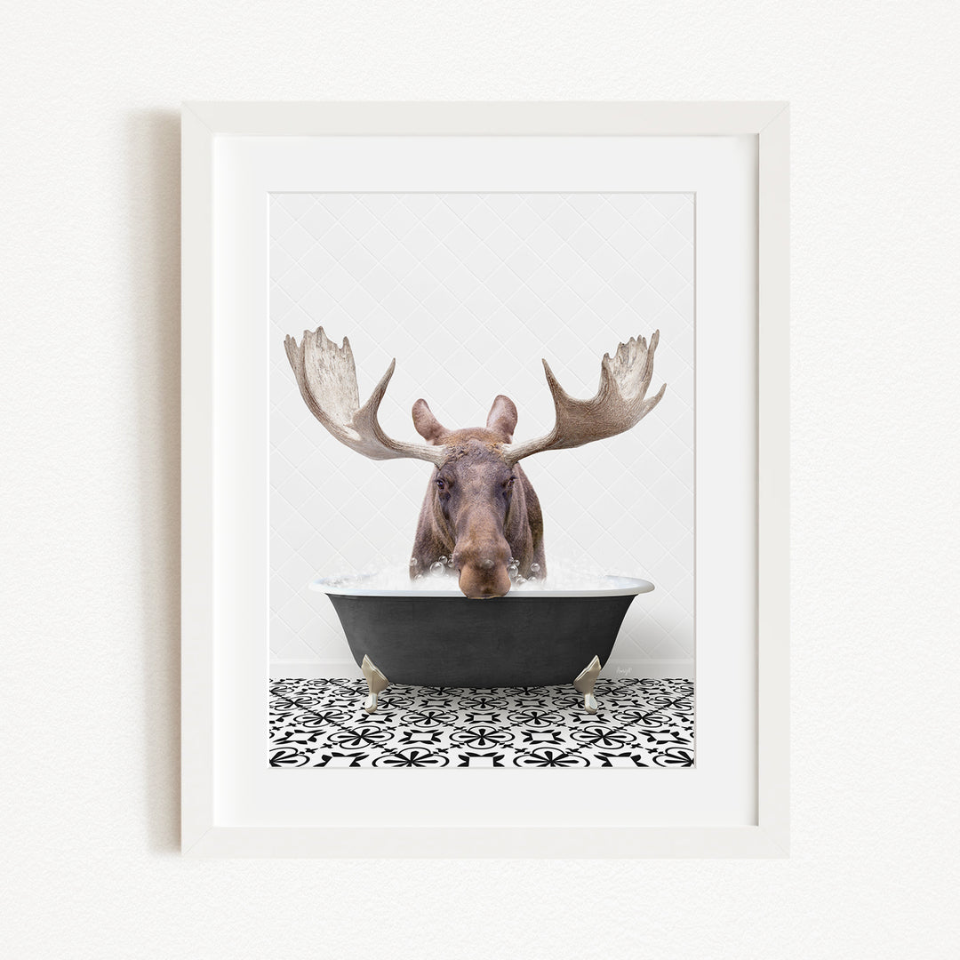 A moose with large antlers is sitting in a bathtub, surrounded by a black and white patterned floor.