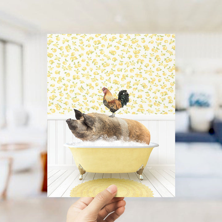 A hand holds up a collage of two images: a pig sitting in a yellow bathtub, and a rooster perched on the pig's back.