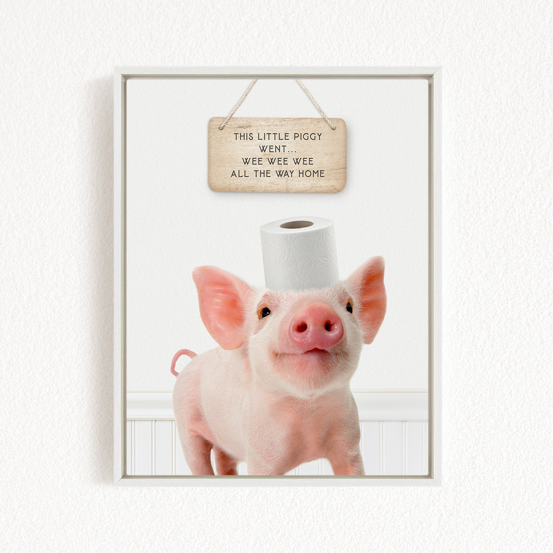 A cute piglet standing on a white surface, with a wooden sign above it that reads "This little piggy went wee wee wee all the way home".