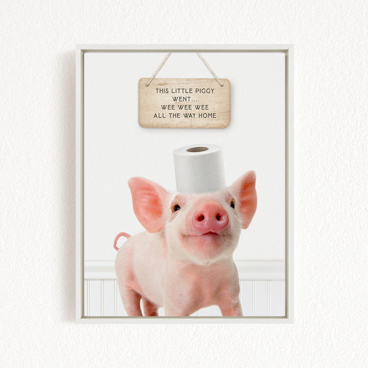 A cute piglet standing on a white surface, with a wooden sign above it that reads "This little piggy went wee wee wee all the way home".