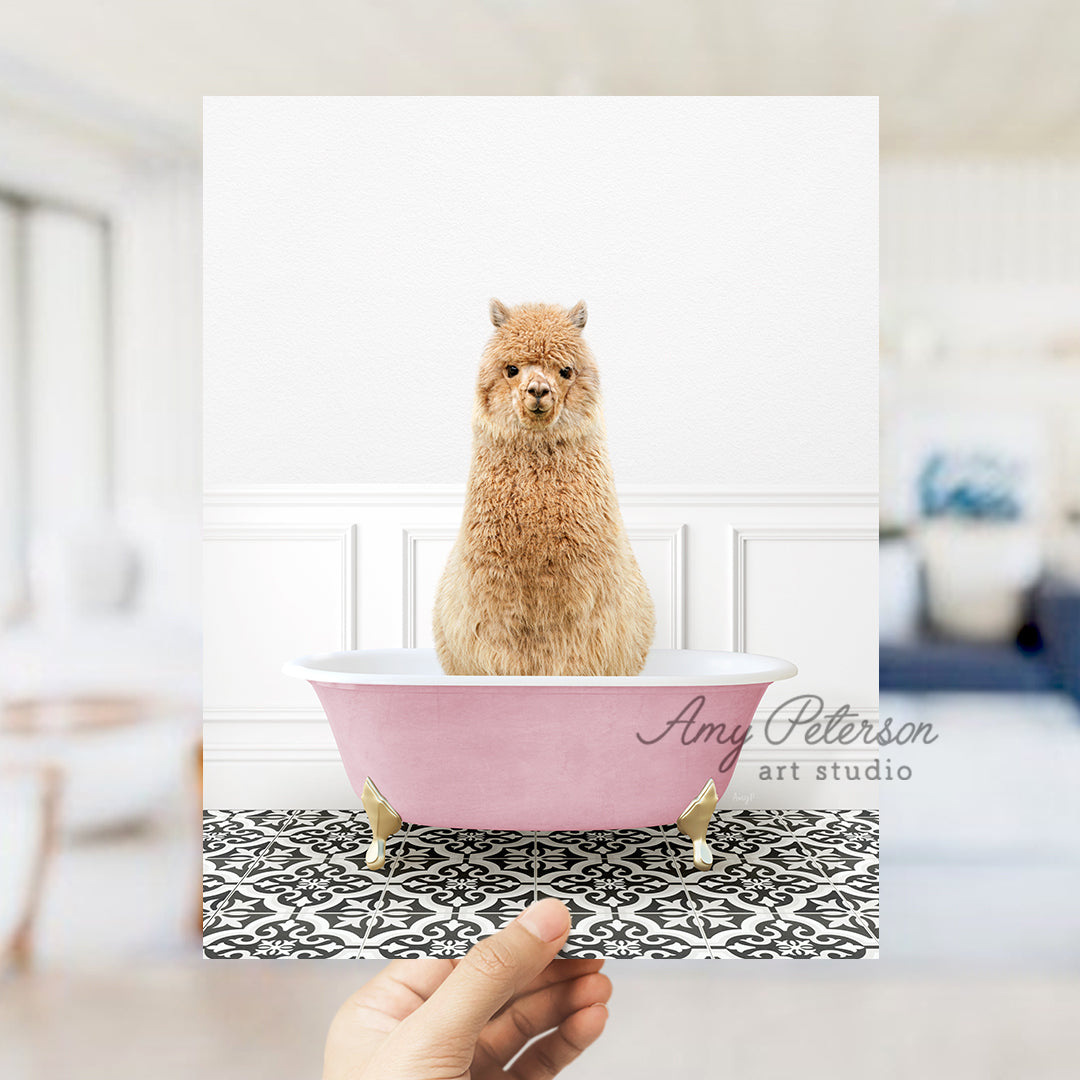 a hand holding a card with a llama in a bathtub