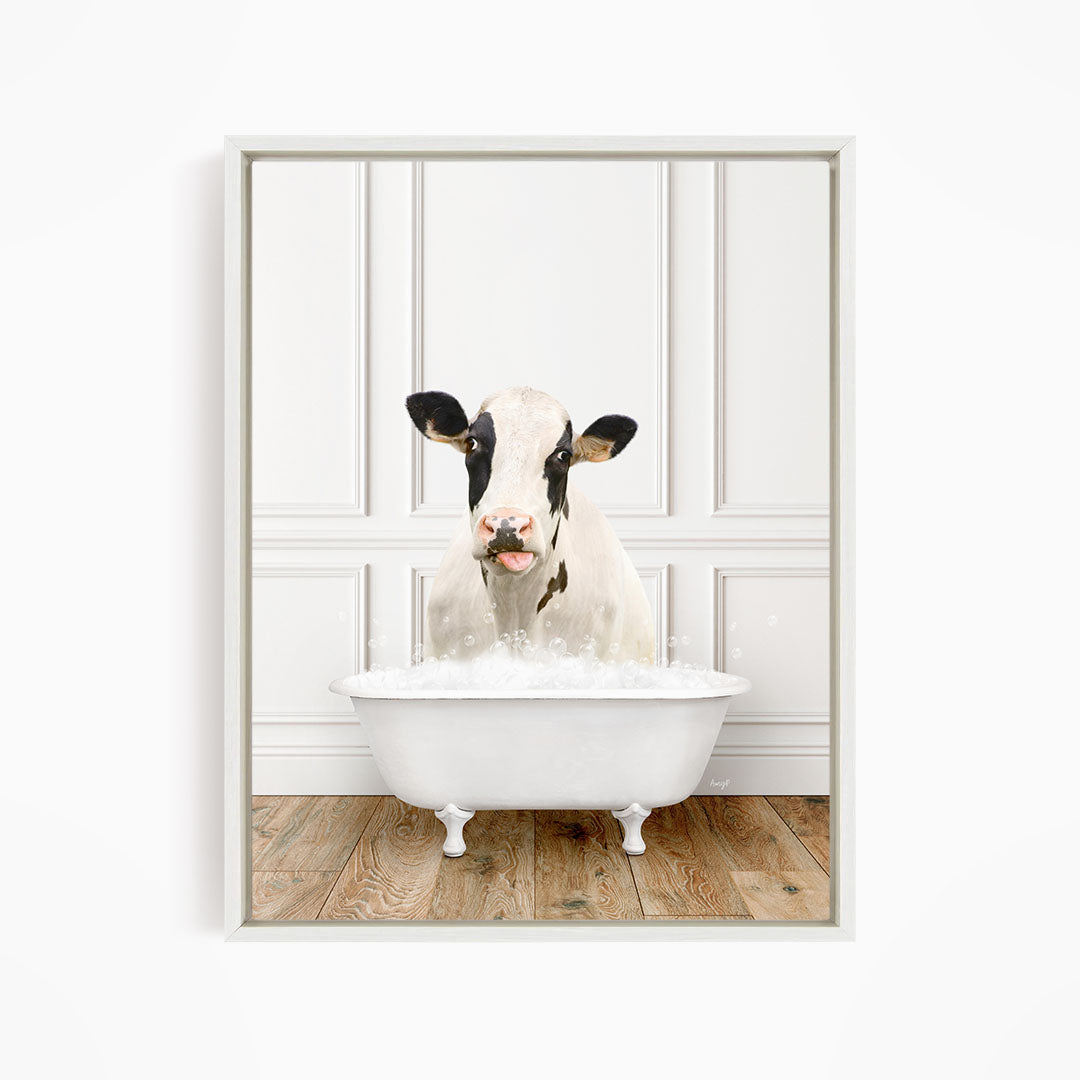 A black and white cow is sitting in a white bathtub filled with water, creating a whimsical and humorous scene.