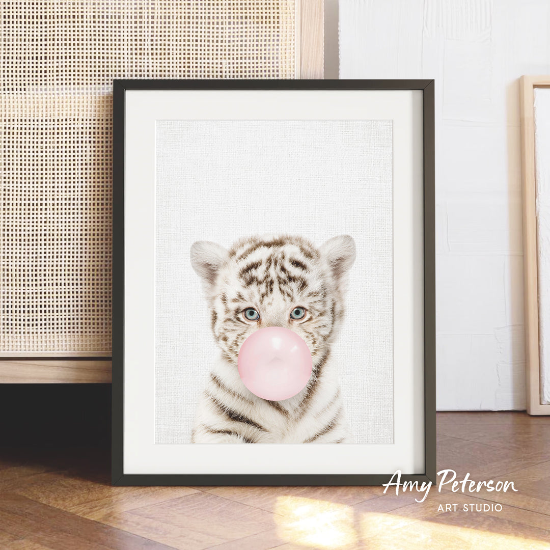 A framed print of a tiger blowing a bubble with a pink bubble gum bubble.