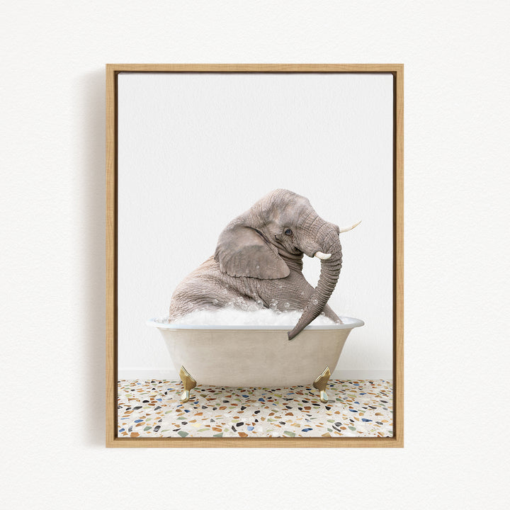 A gray elephant sitting in a white bathtub filled with water, with its trunk submerged in the water.