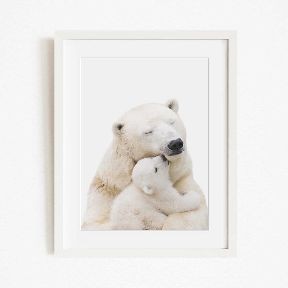A mother polar bear tenderly embracing her cub in a serene, snowy landscape.