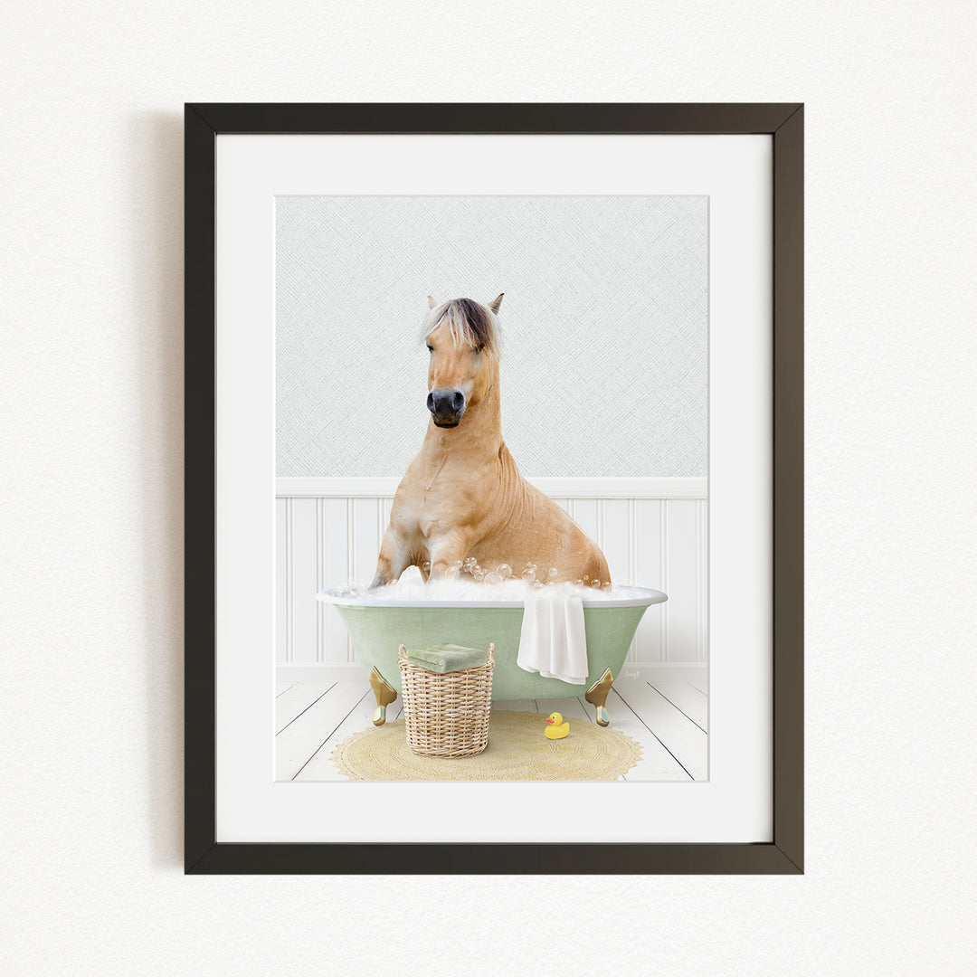 A light brown horse is sitting in a green bathtub filled with water, surrounded by a basket of bath toys and a yellow rubber duck.