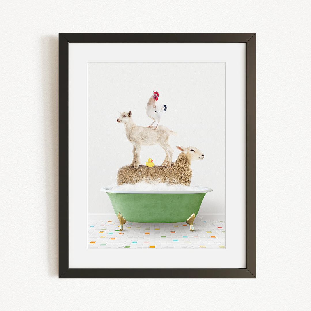 A framed image depicting a sheep standing on a goat's back while a rooster stands on a sheep's back, all atop a green bathtub filled with bubbles.