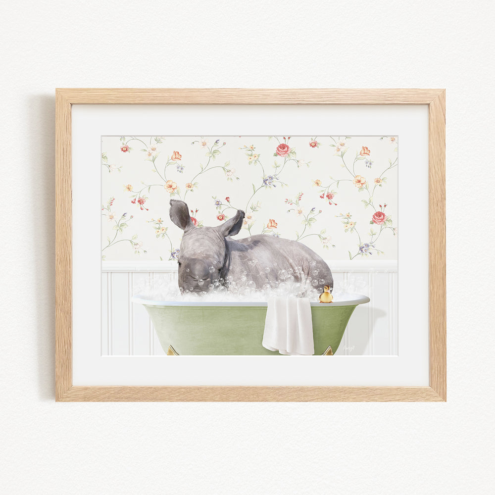 A rhinoceros is sitting in a green bathtub filled with water, surrounded by a floral pattern on the wall behind it.