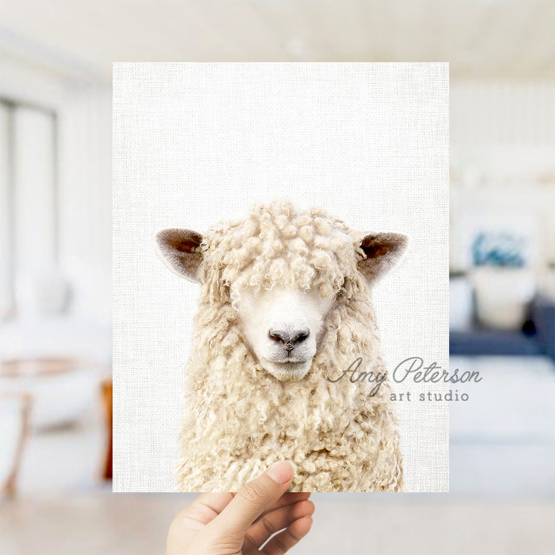 a hand holding up a picture of a sheep